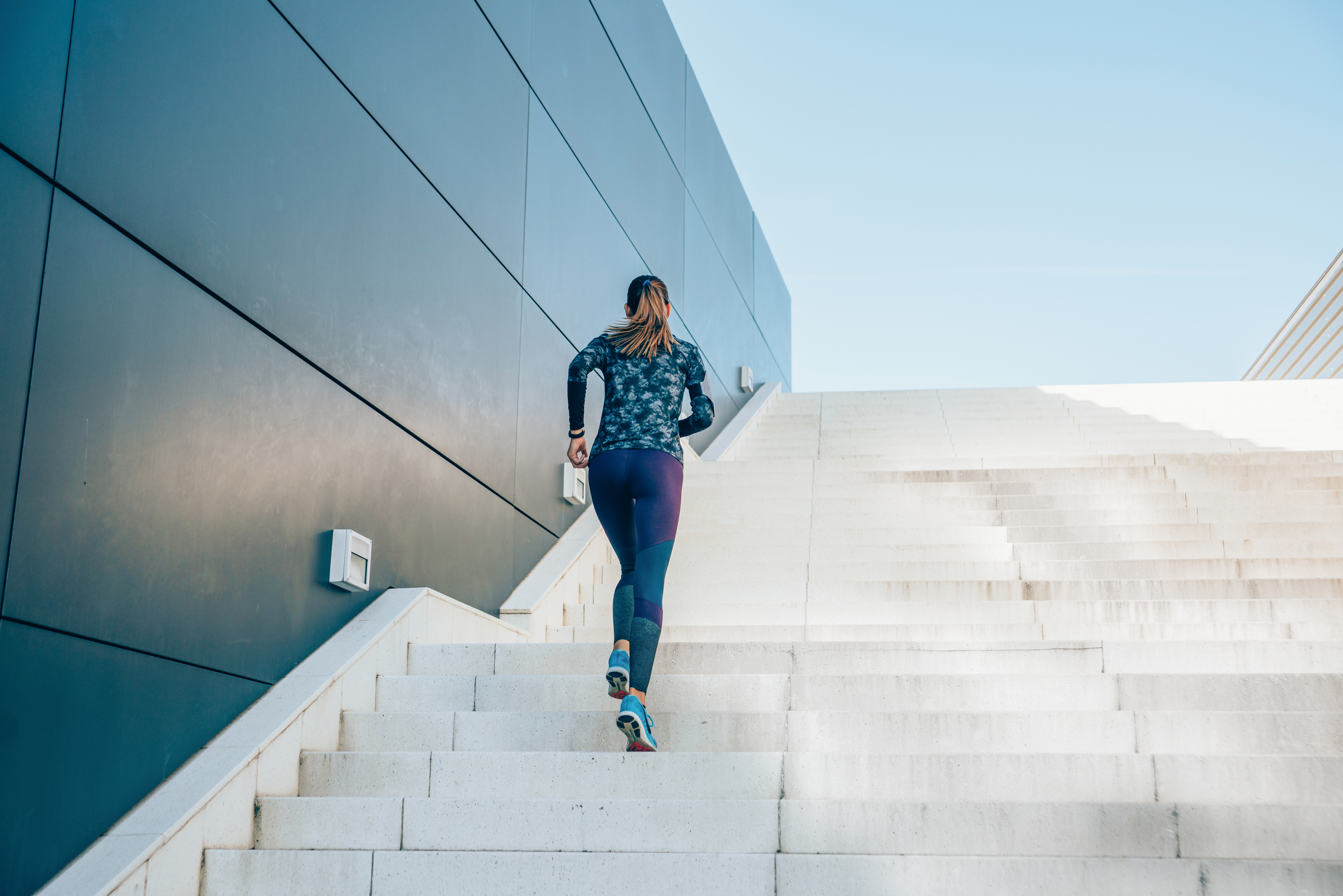 Young sportswoman jogging up the steps.